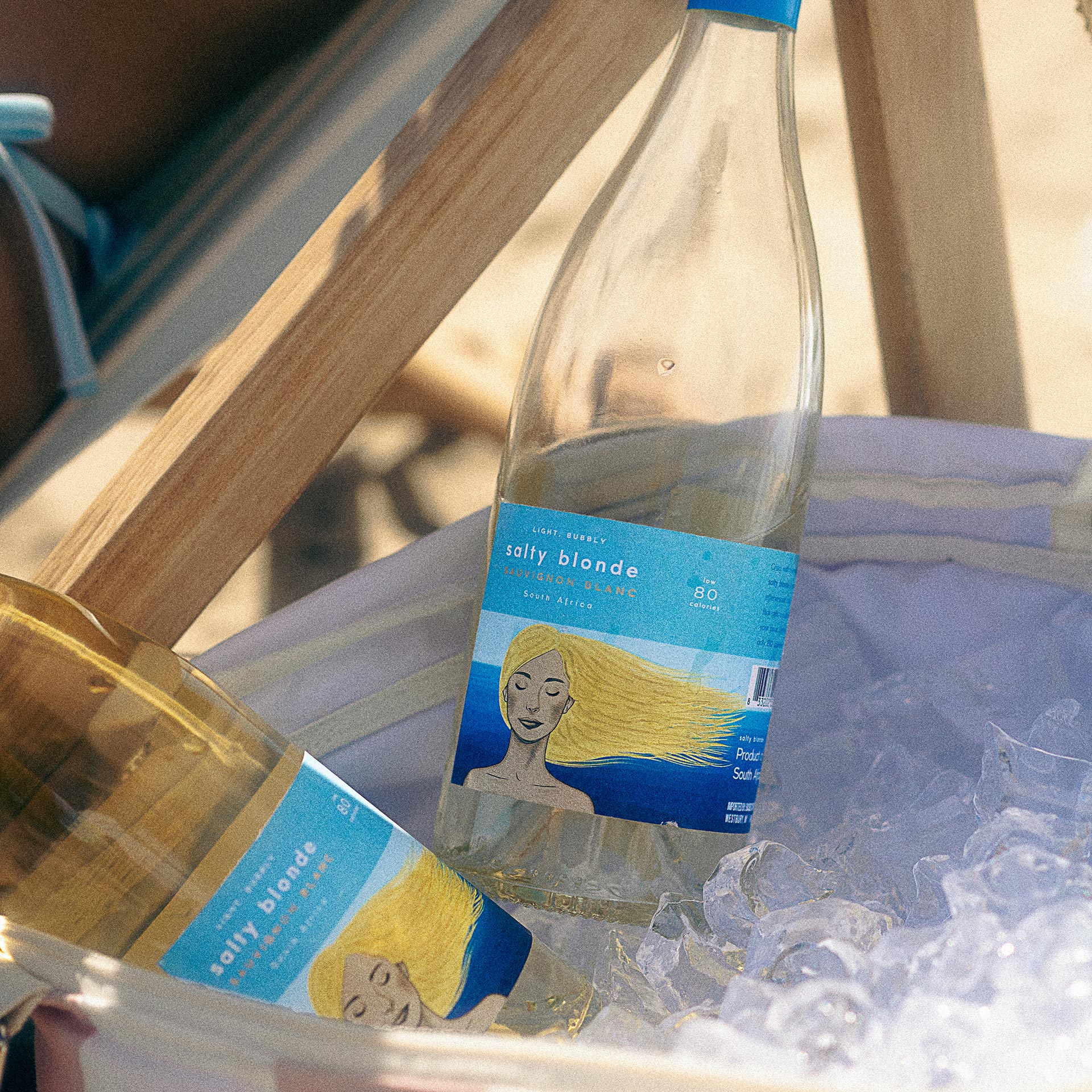 salty blonde wine bottles in cooler at beach