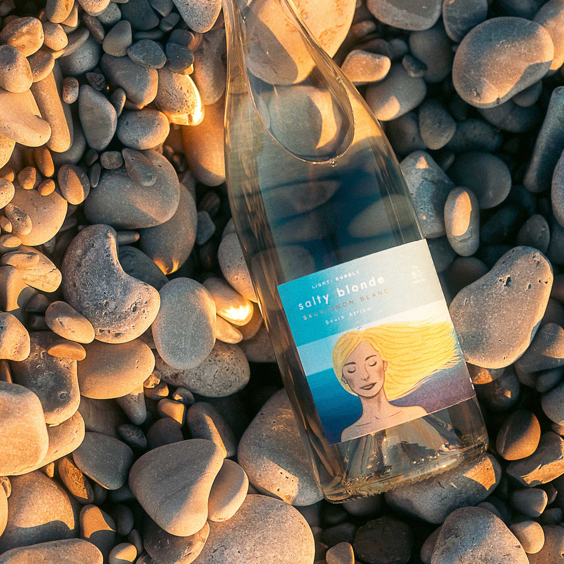 salty blonde wine bottle on stones